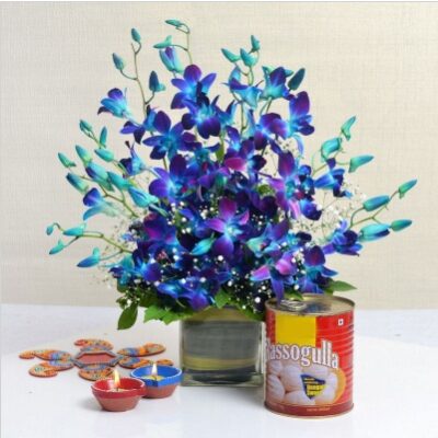 Orchids In Glass Vase And Rasogullas With Diyas